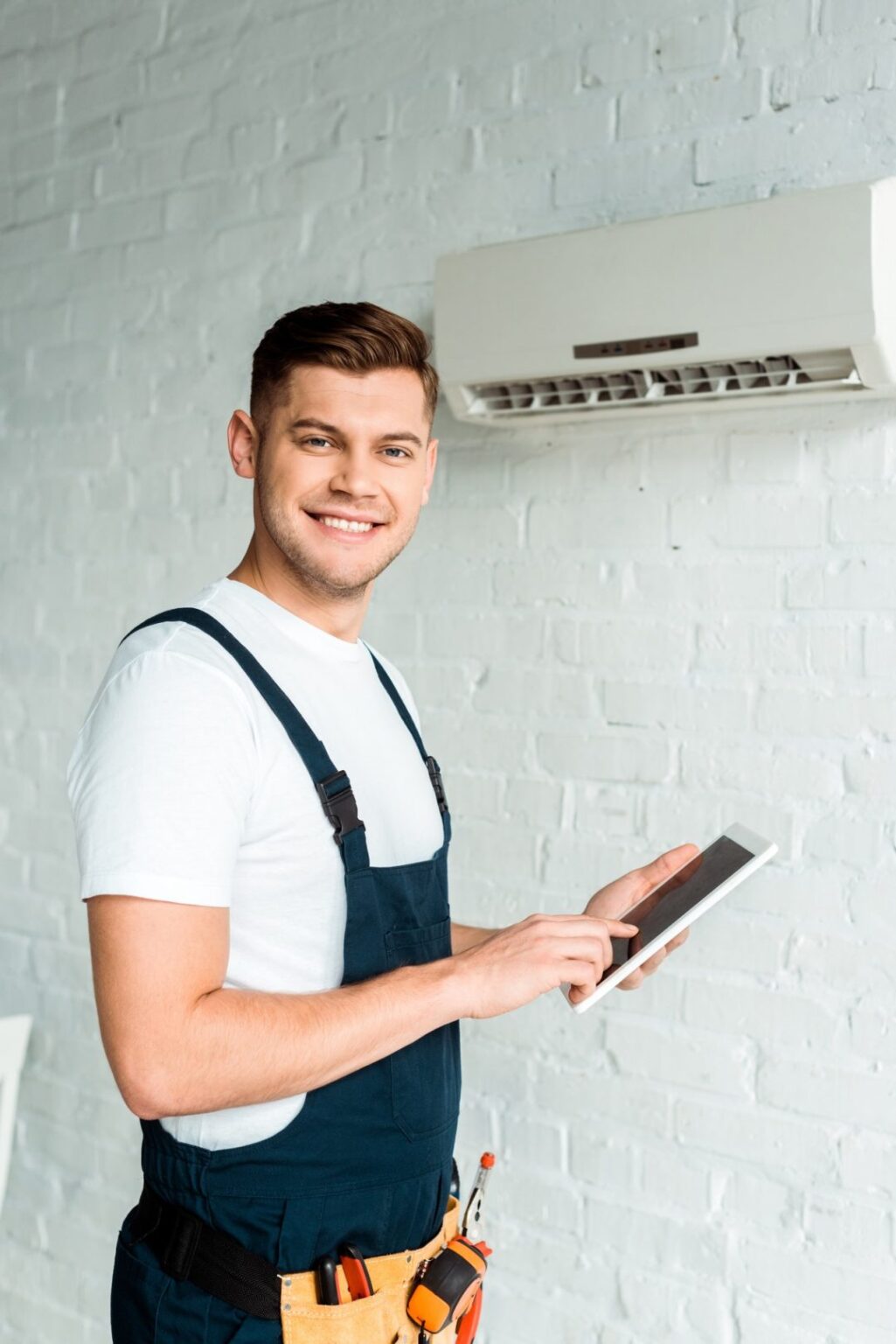 Technicien Oegaz avec tablette pres d'une climatisation